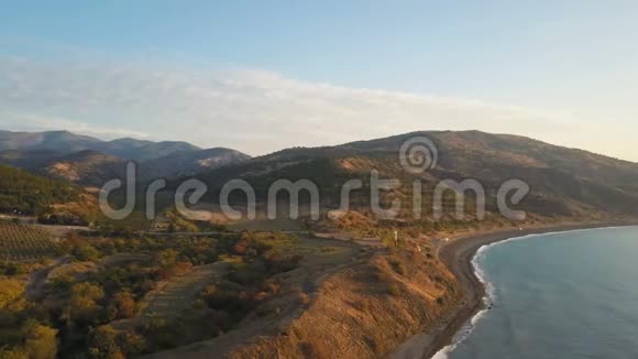 日出时飞越海岸和山脉空中无人机在黑海海岸拍摄了美丽的早晨视频的预览图