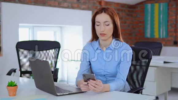 女商人在办公室里用手机视频的预览图