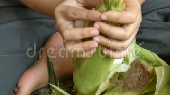 紧紧抓住女人的手剥着新鲜的生甜玉米准备做饭视频的预览图