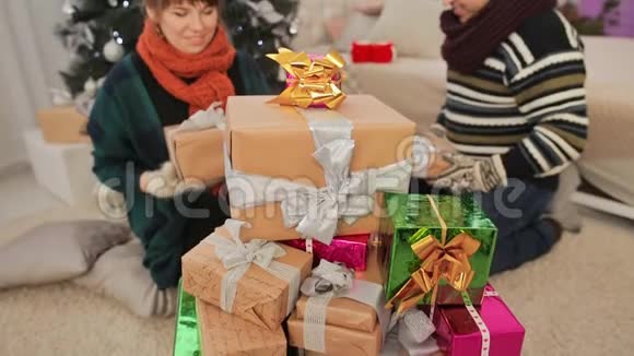年轻夫妇欣赏圣诞礼物并送给观众新年主题视频的预览图