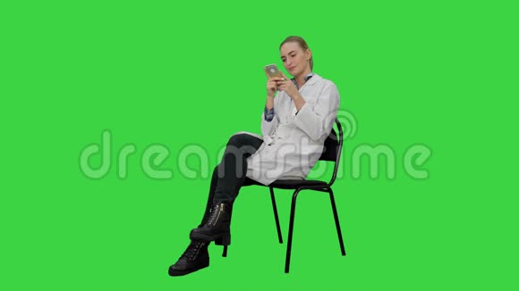 女医生用智能手机在绿色屏幕上给病人发短信Chroma键视频的预览图