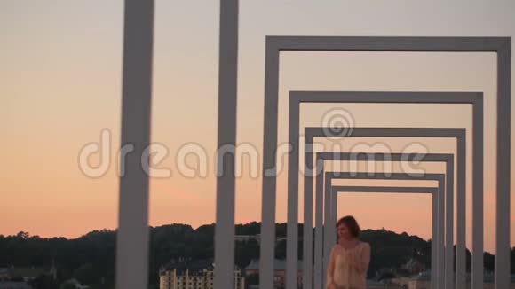 可爱的年轻城市时尚女性在日落时走在高科技城市桥上视频的预览图