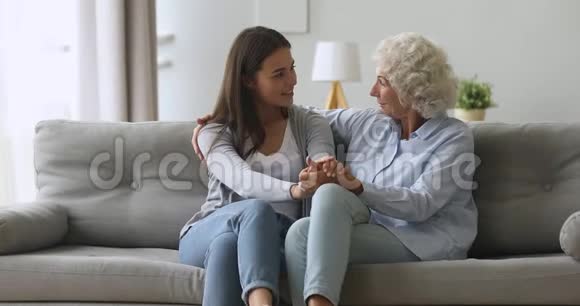 快乐的小女儿和高年级的妈妈在家里聊天视频的预览图