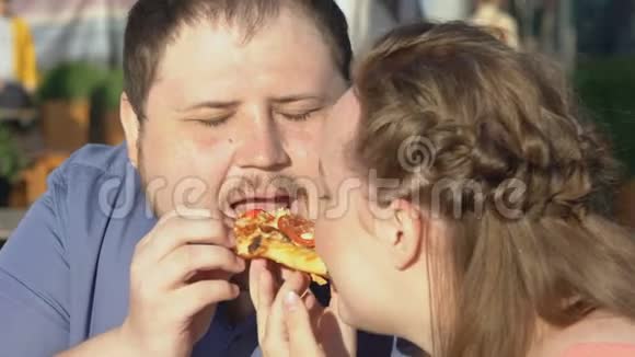 胖男女朋友在户外吃披萨浪漫约会吃垃圾食品视频的预览图
