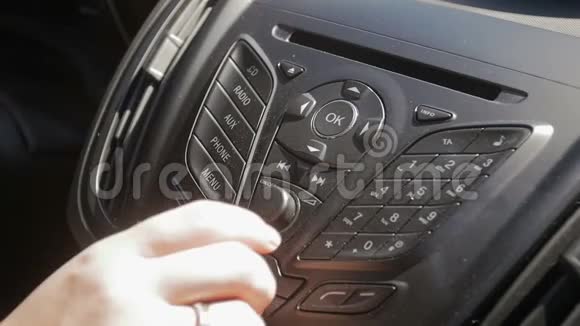 慢动作特写镜头司机手调整音乐音量在汽车仪表板视频的预览图
