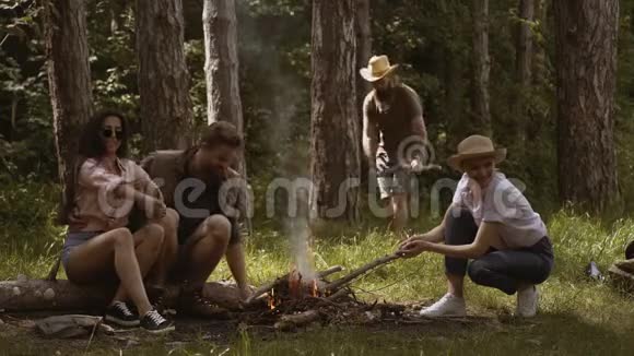 一群朋友露营他们坐在篝火旁露营的年轻人视频的预览图