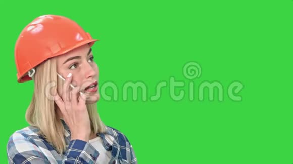 穿橙色头盔的女人打电话讨论绿色屏幕上的物体的问题Chroma键视频的预览图