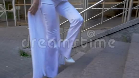 一个穿白色西装的女人爬楼梯视频的预览图