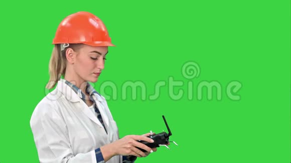 女建筑工人操作起重机使用遥控器上的绿色屏幕铬键视频的预览图