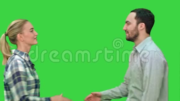 青少年握手看着绿色屏幕上的相机Chroma键视频的预览图