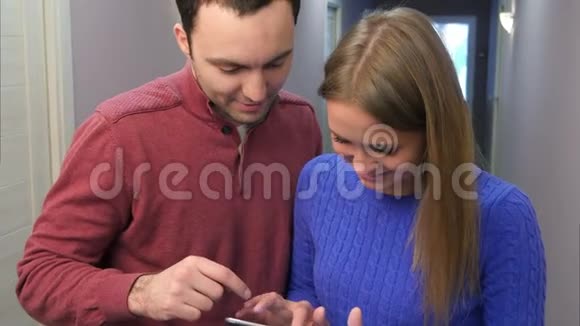 微笑的情侣在酒店走廊上玩平板电脑视频的预览图