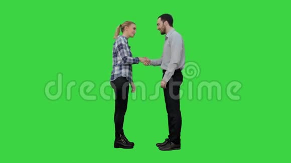年轻人很高兴在绿色屏幕上遇到彼此握手Chroma键视频的预览图