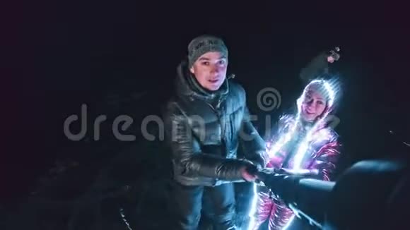 家人是滑冰之夜做自拍母亲父亲女儿和儿子一起骑在冰缝里室外视频的预览图