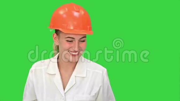 年轻的女建筑工程师微笑同时有一个视频会议与笔记本电脑上的绿色屏幕铬键视频的预览图