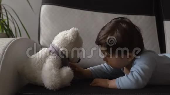 妈妈在玩玩具熊和她的小儿子室内公寓亚洲混血孩子穿蓝色体恤视频的预览图