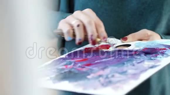 艺术家将不同颜色的丙烯酸涂料与画笔混合绘制绘制图片的颜色准备视频的预览图