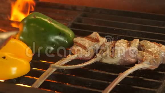 骨头上的三块牛排和两半的胡椒烤从烤煤里有一个火焰一道菜在里面视频的预览图