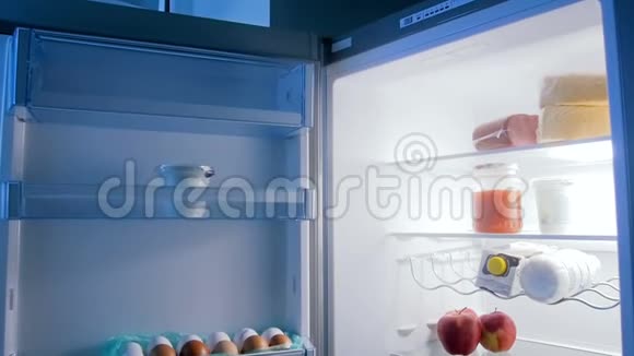 厨房里充满食物的开放式冰箱的慢镜头视频的预览图
