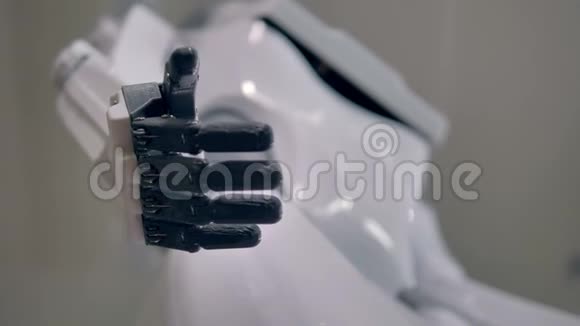 一个休息的机器人手掌黑色的手指收缩到白色的身体4K视频的预览图