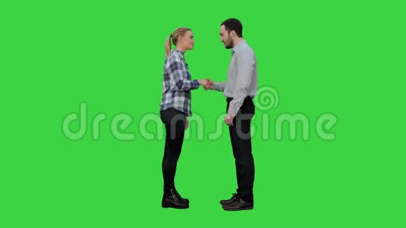 两个年轻人随意握手看着相机和拇指向上的绿色屏幕Chroma键视频的预览图