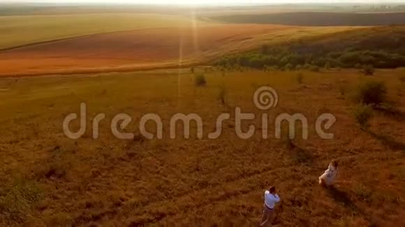 性感的年轻情侣在背景草地上相爱爱的一对夫妇享受大自然在田野上的生活Aerutazh视频的预览图