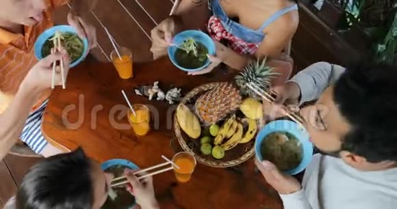 人们吃美味的面条汤亚洲食物朋友小组互相喂食坐在桌面视角视频的预览图