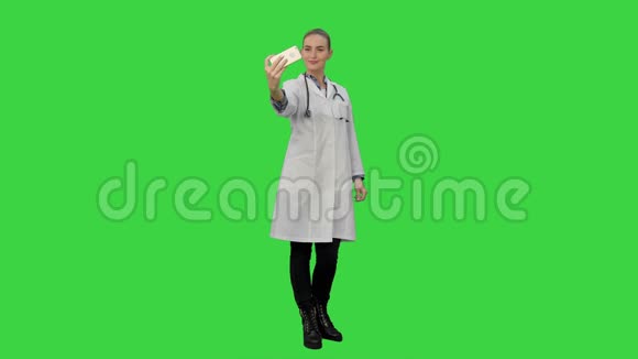 年轻漂亮的女医生在智能手机上自拍在绿色屏幕上微笑Chroma键视频的预览图