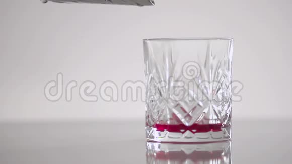 白色背景玻璃中的深红色液体视频的预览图