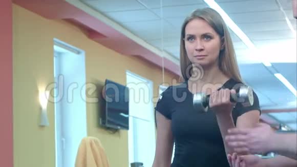 女子与她的私人健身教练在健身房锻炼力量体操与杠铃视频的预览图