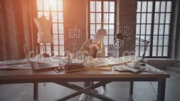 女时装设计师坐在她的办公桌上为新服装系列绘制素描视频的预览图