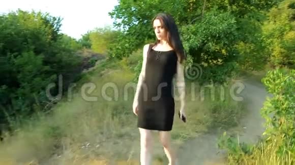 一个穿着黑色裙子走在街上的年轻美女视频的预览图