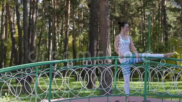 在桥上的公园里做瑜伽的女人健康生活方式视频的预览图