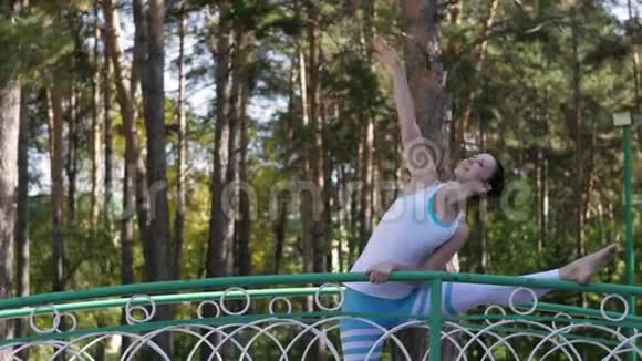 在桥上的公园里做瑜伽的女人健康生活方式视频的预览图