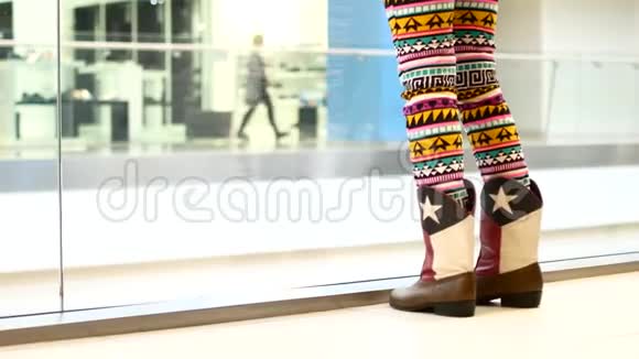穿着皮靴的女性脚一个女孩站在购物中心里视频的预览图