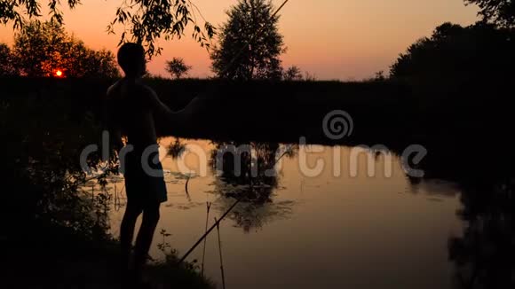 日落时河岸上一个渔夫的剪影视频的预览图