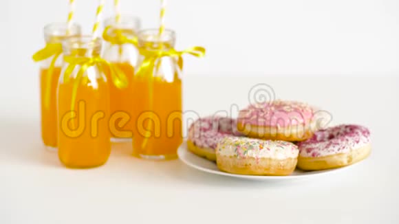 甜甜圈和柠檬水或玻璃瓶中的果汁视频的预览图