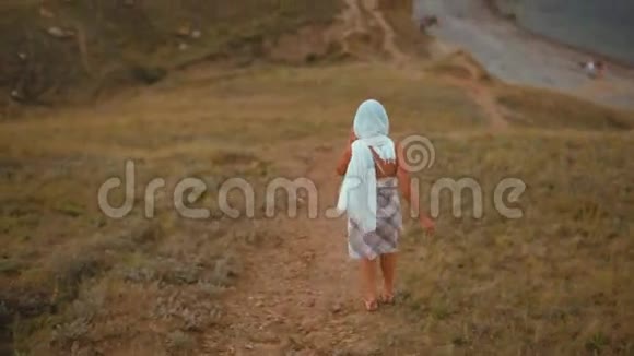 穿着头巾的瘦小的年轻女士和穿着山上山下海的衣服视频的预览图