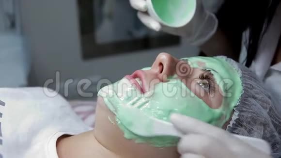 美容师用海藻酸钠面膜敷在病人的脸上后进行生物消毒视频的预览图