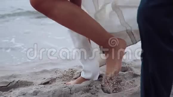 新娘和新郎穿着婚纱和他们的狗一起去美丽的海滩视频的预览图