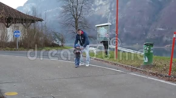 年轻的父亲和儿子在阿尔卑斯山的背景下玩耍视频的预览图