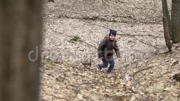 快乐男孩的欧洲外观跑上森林小径慢动作视频的预览图