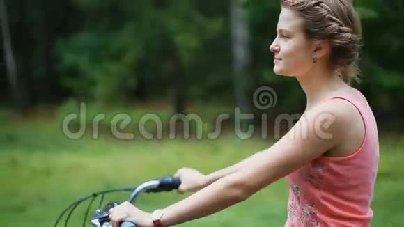 夏天下雨后一位年轻的女士骑着老式自行车在森林路上视频的预览图