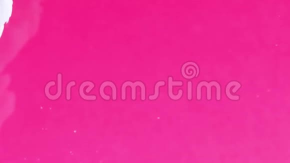 墨水在水里白色油漆在粉红色反应在水中创造抽象的云形可用作转换添加视频的预览图
