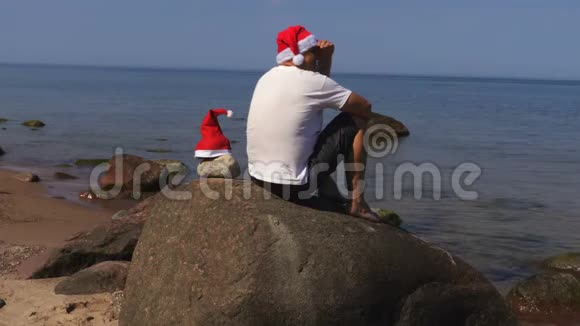 戴着圣诞帽的人在海边放松视频的预览图