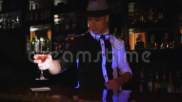 慢动作接近一个酒保把一个鸡尾酒杯放在木条上视频的预览图