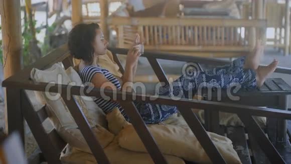 巴厘岛上的活动一个穿着条纹T恤和宽松裤子的短发女孩穿着宽松的衣服视频的预览图