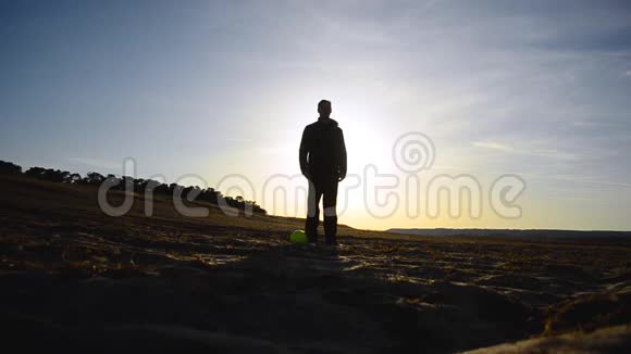 站在阳光照耀下的沙滩上的人的剪影视频的预览图