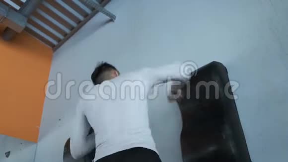 一个年轻的亚洲人正在跆拳道健身房训练视频的预览图
