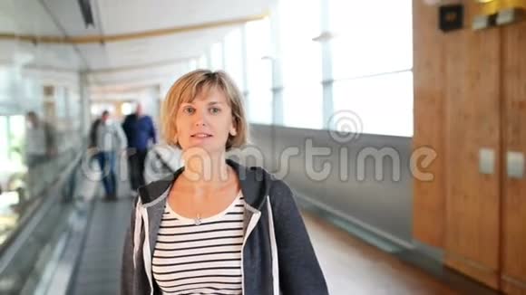 站在机场移动通道上的女人视频的预览图