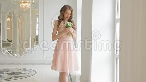 美丽的未婚妻穿着美丽的米色连衣裙带着一束山谷百合花视频的预览图